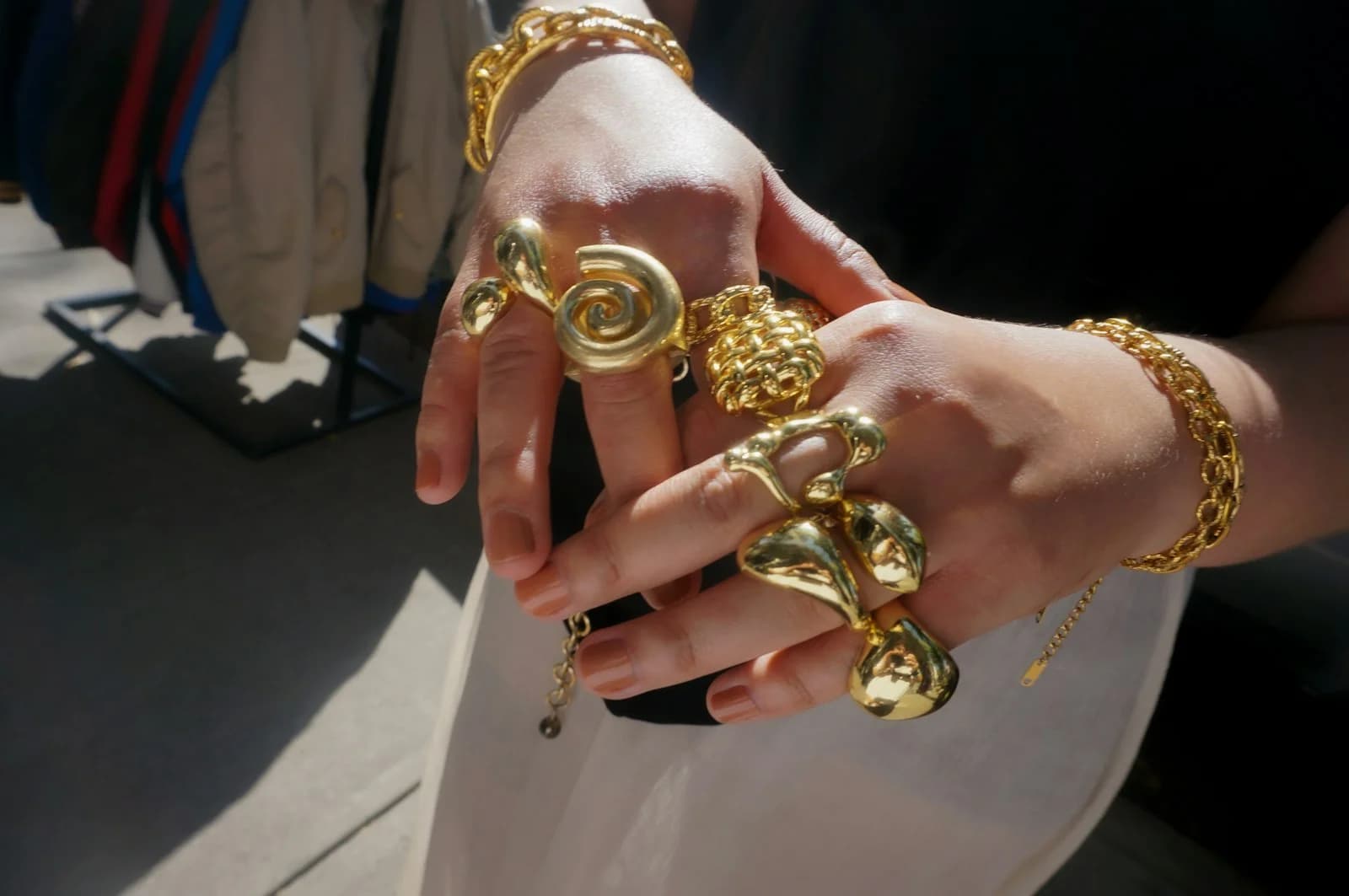 Close-up of gold rings and bracelets on hand in warm sunlight