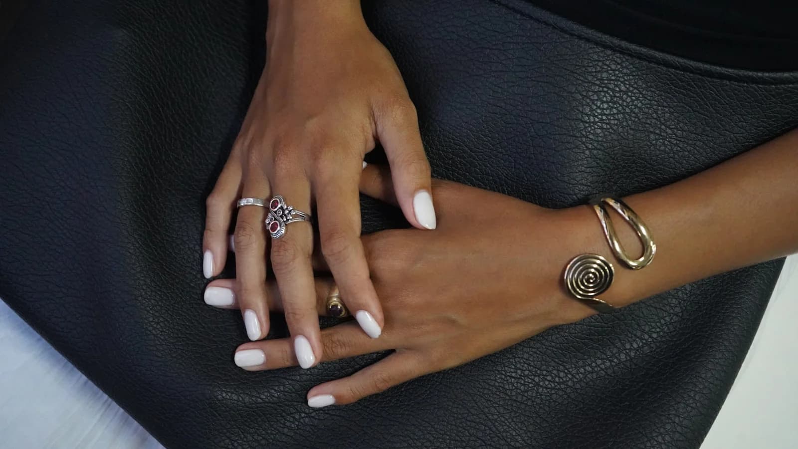 Hands wearing gold and silver jewelry together